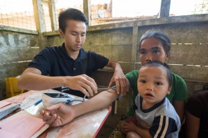 A pharmacy student measuring blood pressure for the villagers. 